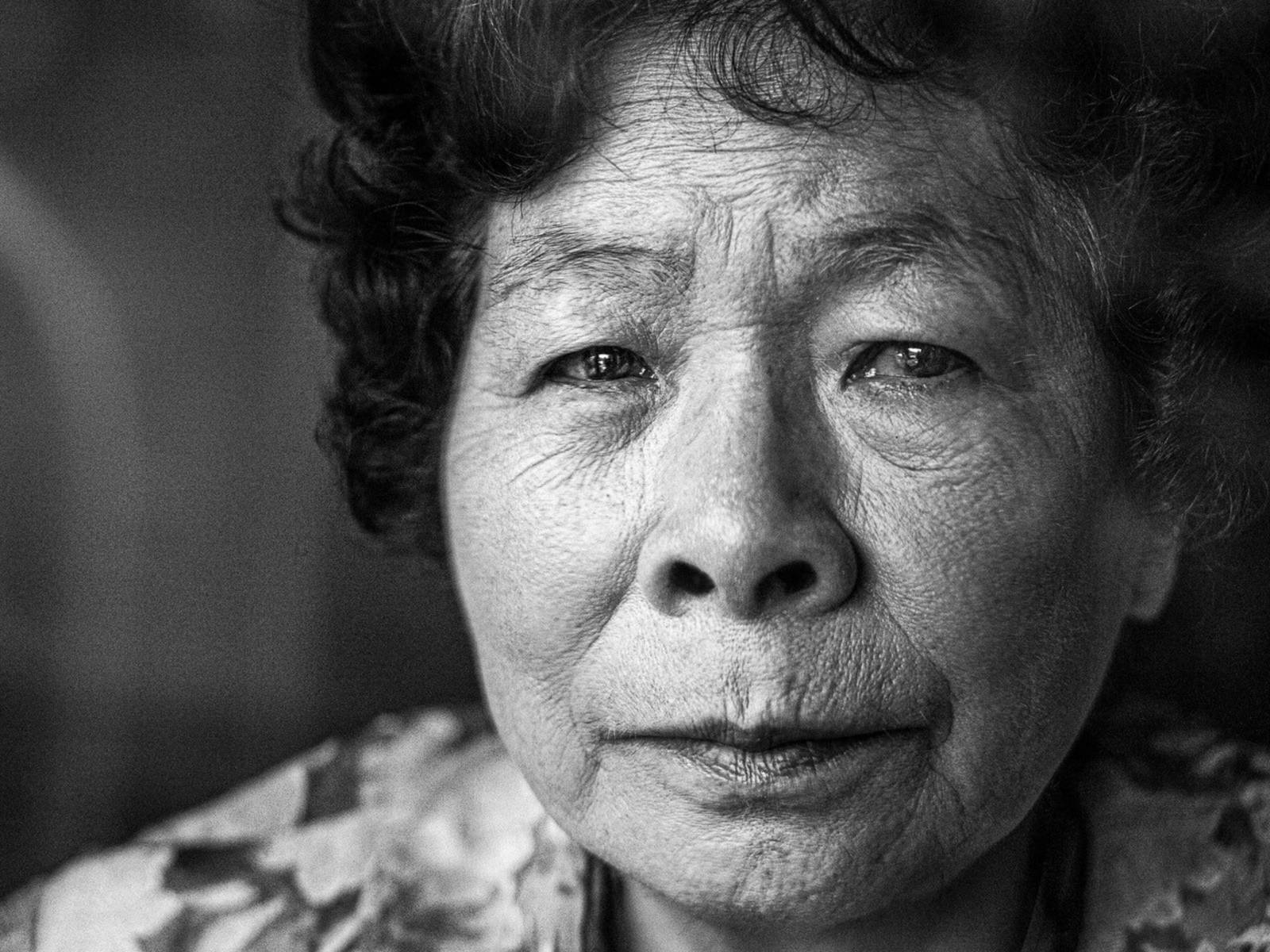 Eine ältere Dame, die den Atombombenabwurf auf Hiroshima überlebt hat. Schwarz/weiß-Bild, Nahaufnahme.